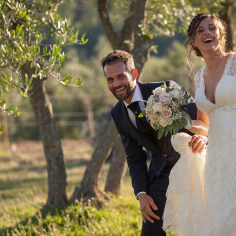 sposi felici e sorridenti alla fattoria dell'agriturismo di Colleoli con la luce del tramonto
